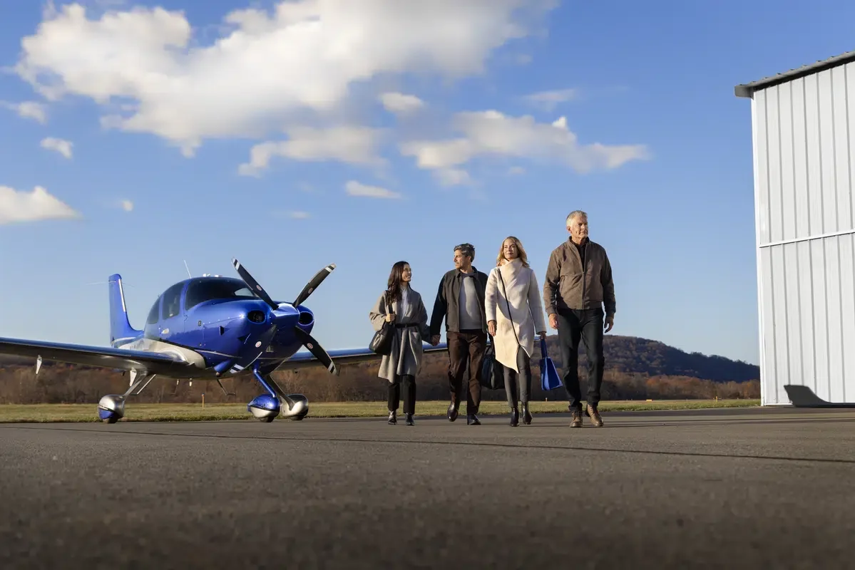 group of people walking away from cirrus plane. 
